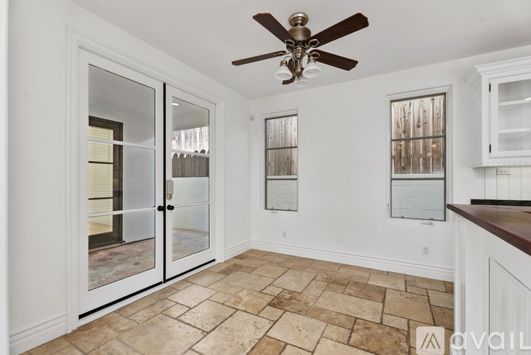 A modern kitchen with a large island and pendant lights.