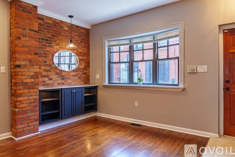 A room with a brick wall and a round window.