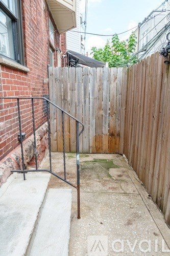 A wooden fence and gate in front of a brick building.