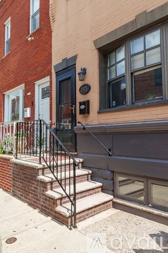 A red brick building with a black door and a mailbox on the front.
