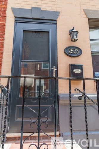 A black door with a glass window and a metal grill.