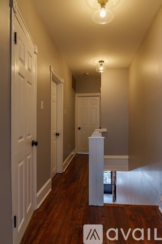 A hallway with a white pillar in the middle and a sign that says "avail".
