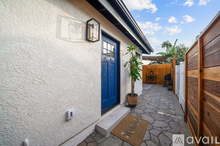 A house with a blue door and a brown mat on the ground.