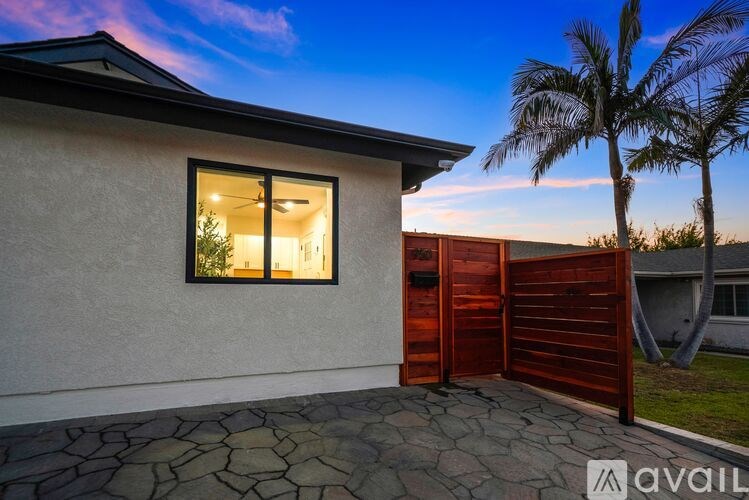 A house with a red gate and a stone patio.