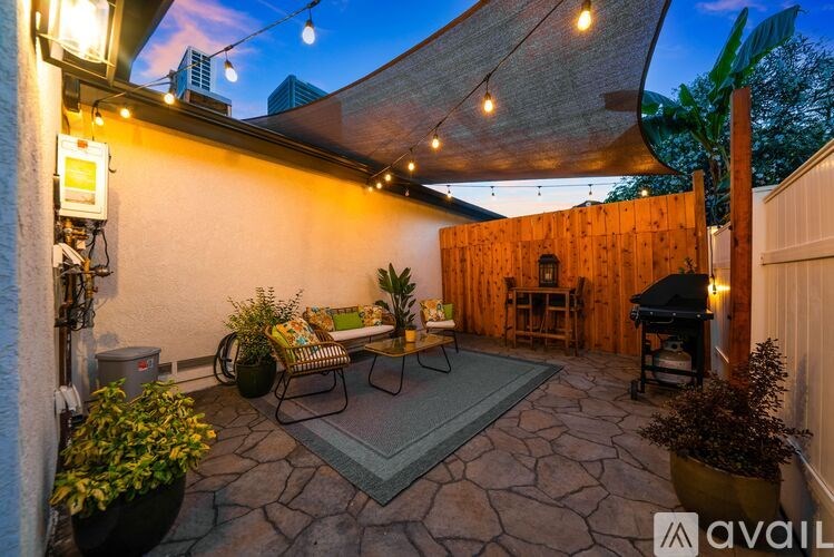 A patio with a table and chairs under a canopy.