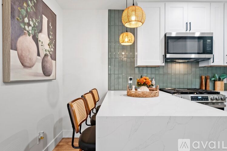 A kitchen with a white countertop and a painting of vases on the wall.