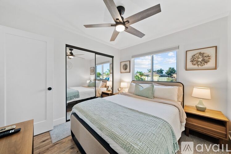 A bedroom with a large bed and a ceiling fan.