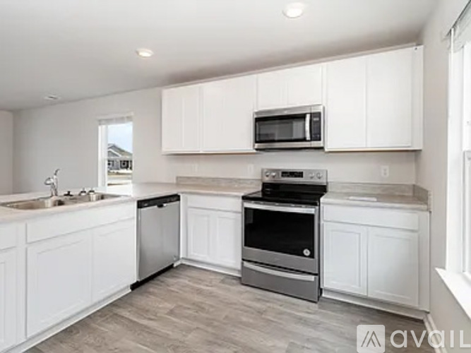 A modern kitchen with white cabinets and stainless steel appliances.