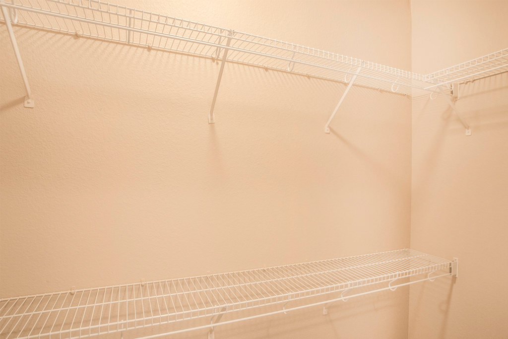 a large walk in closet in a bathroom with a wire shelf