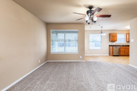 A room with a ceiling fan and a window with blinds.
