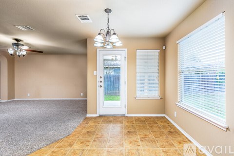 A room with a door, a fan, and a chandelier.