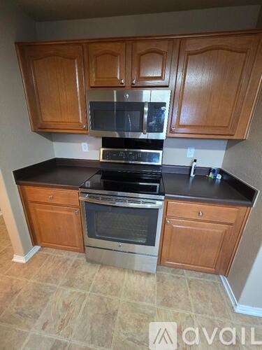 A kitchen with wooden cabinets and a black countertop.