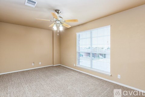 A room with a ceiling fan and a window with blinds.