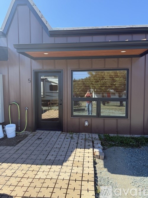 A house numbered 5 with a black door and a window.
