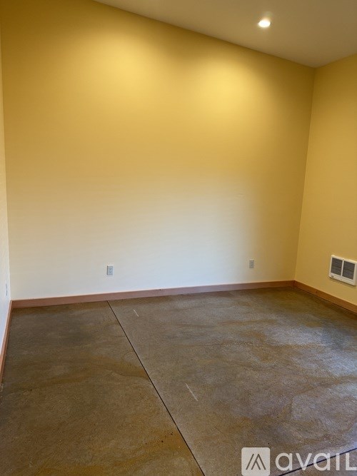 A room with a concrete floor and a window on the wall.