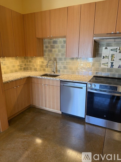 A kitchen with wooden cabinets and a stainless steel dishwasher.