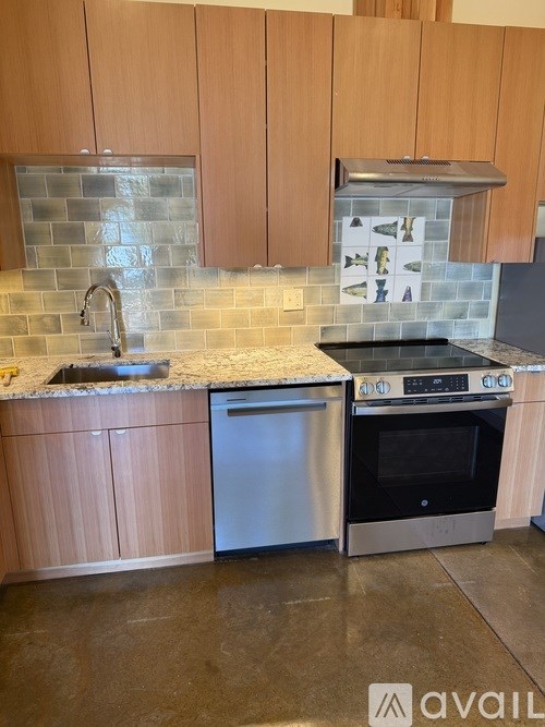 A kitchen with wooden cabinets and a tiled backsplash.