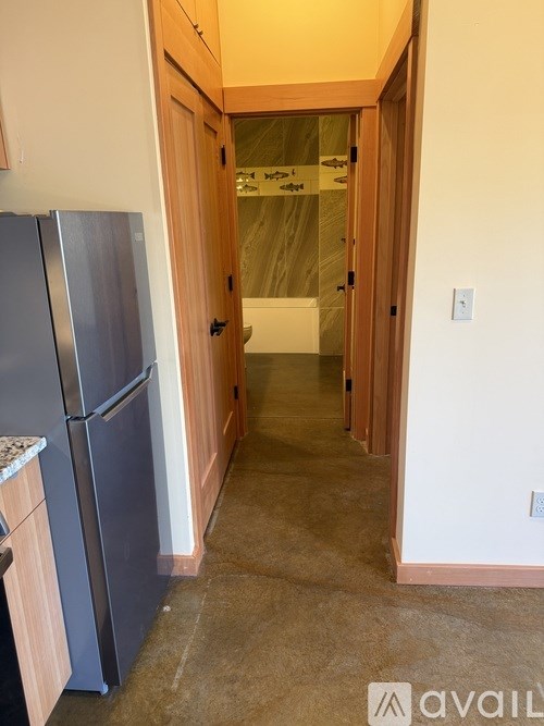 A kitchen with a refrigerator and wooden cabinets.