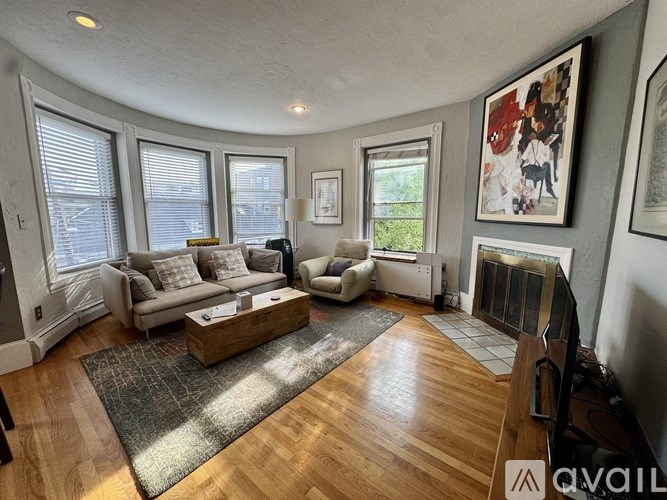 A living room with a large window and a flat screen TV.