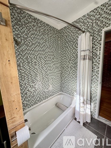A bathroom with a white tub and a shower curtain.