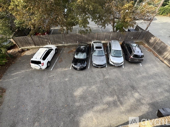 A parking lot with five cars parked in it.