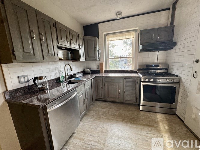 A kitchen with a stainless steel refrigerator, oven, and sink.