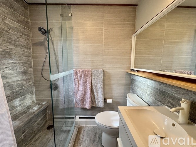 A bathroom with a toilet, sink, and shower.