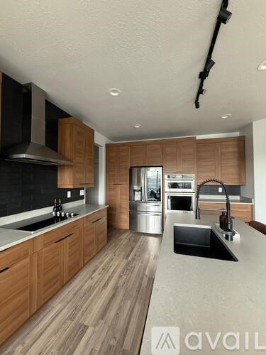 A modern kitchen with wooden cabinets and stainless steel appliances.