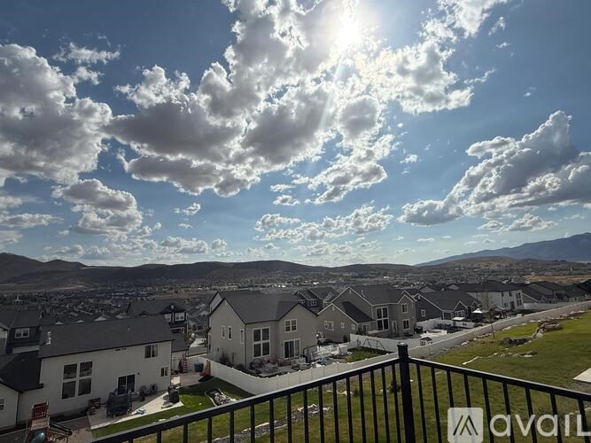 A sunny day in a residential area with houses and a mountain in the distance.