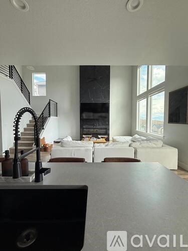 A living room with a staircase and a dining table.