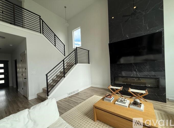 A living room with a fireplace and a staircase.