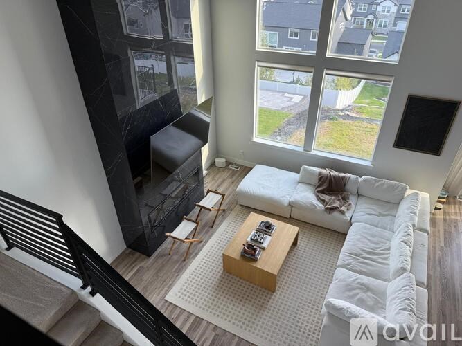 A living room with a white couch and a coffee table in front of a large window.