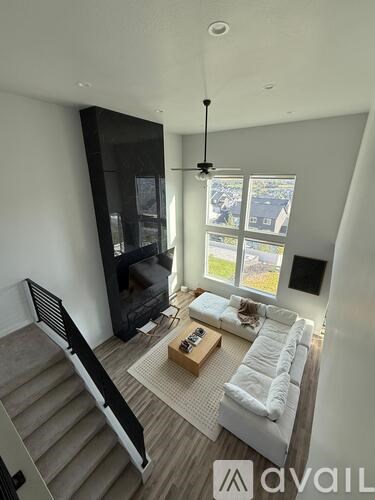 A living room with a couch, a coffee table, and a staircase.