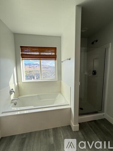 A bathroom with a large tub and a window with blinds.