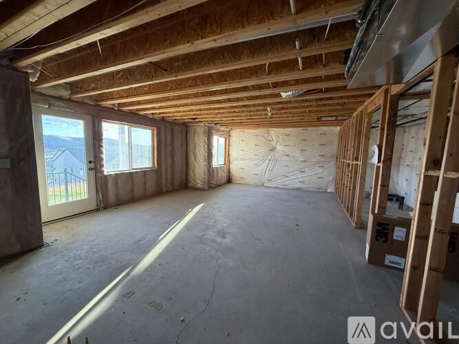 A room under construction with wooden beams on the ceiling.