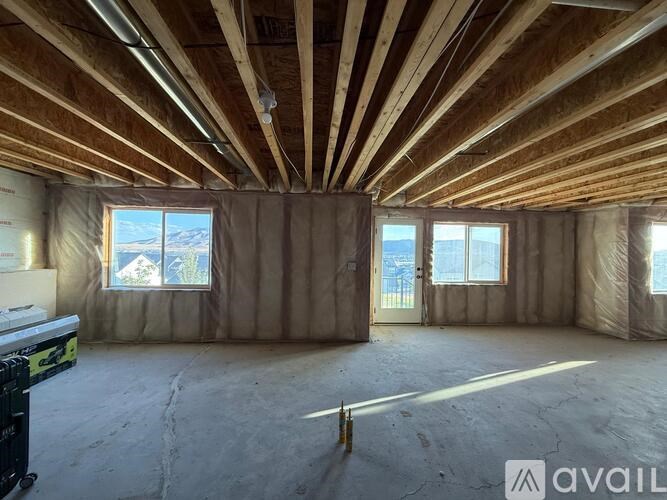 A room under construction with wooden beams on the ceiling.
