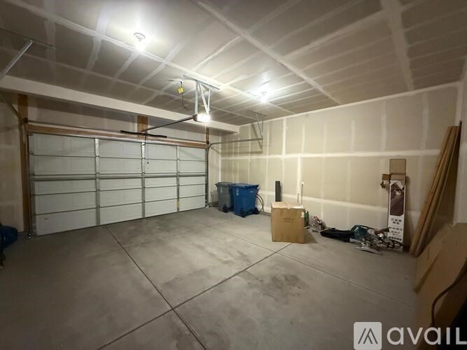 A spacious garage with a white ceiling and a closed white garage door.
