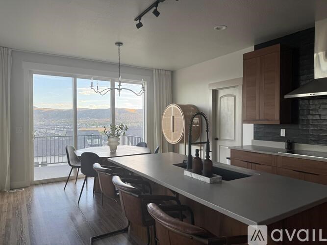 A modern kitchen with a large island and a view of the city.