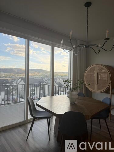 A dining room with a table, chairs, and a view of the city.