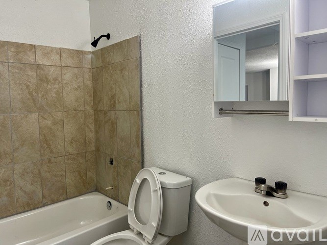 A bathroom with a toilet, sink, and mirror.