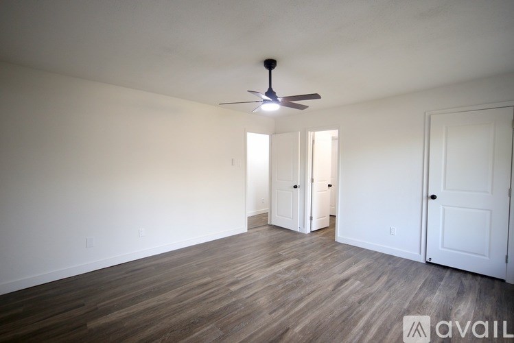 A room with a ceiling fan and a window showing an outdoor view.