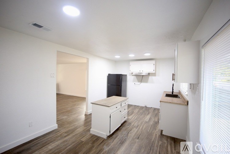 A room with a ceiling fan and wooden flooring.