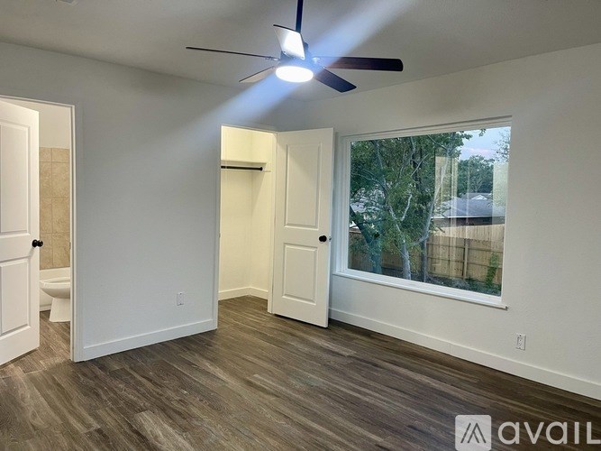 A room with a ceiling fan and a window showing an outdoor view.
