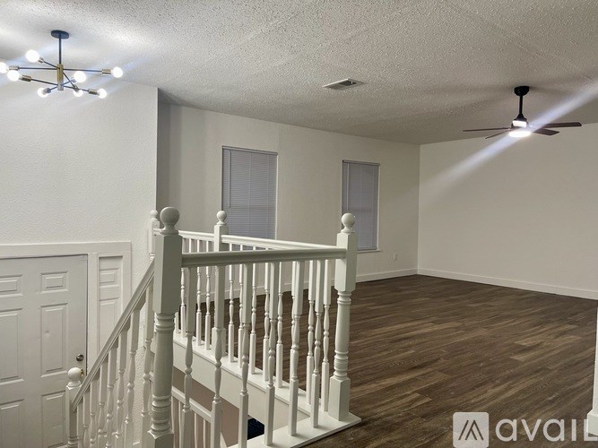 A room with a staircase and a ceiling fan.