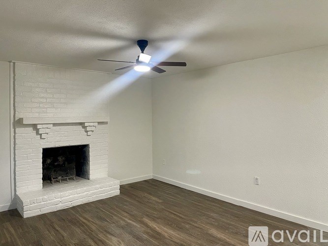 A room with a fireplace and a ceiling fan.