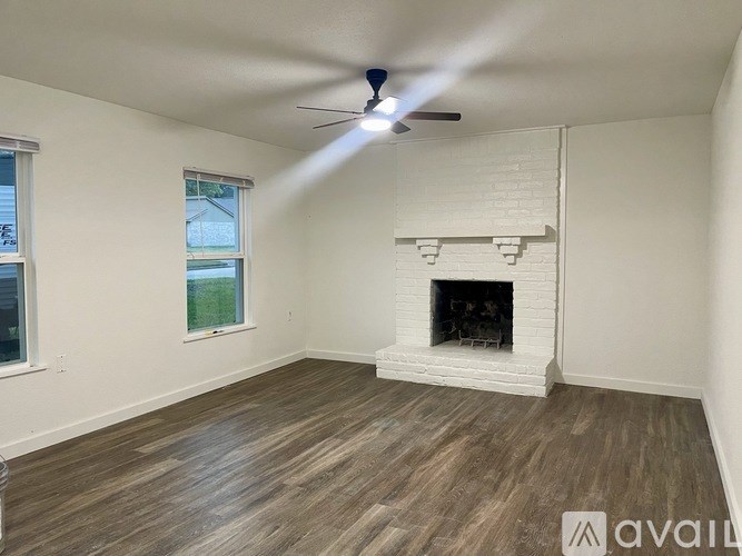 A room with a fireplace and a ceiling fan.