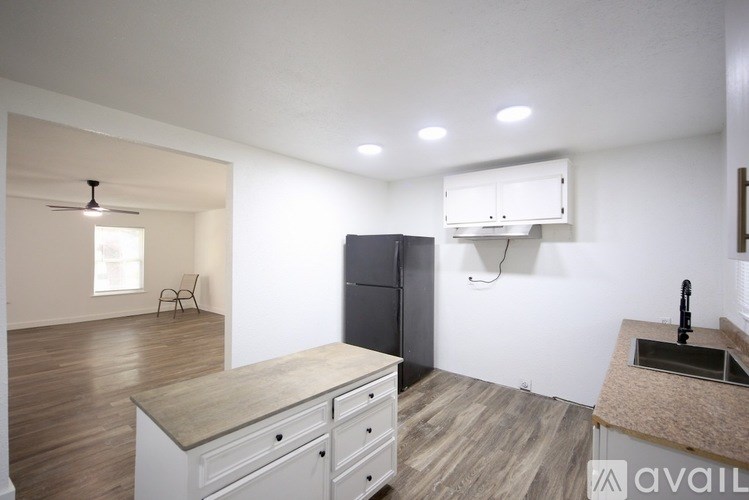 A room with a ceiling fan and light, and a door on the left.