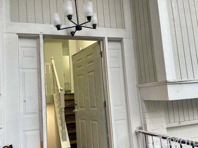 A chandelier hangs over a white door.