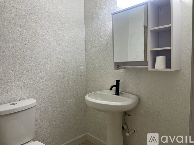 A white sink with a black faucet in a bathroom.