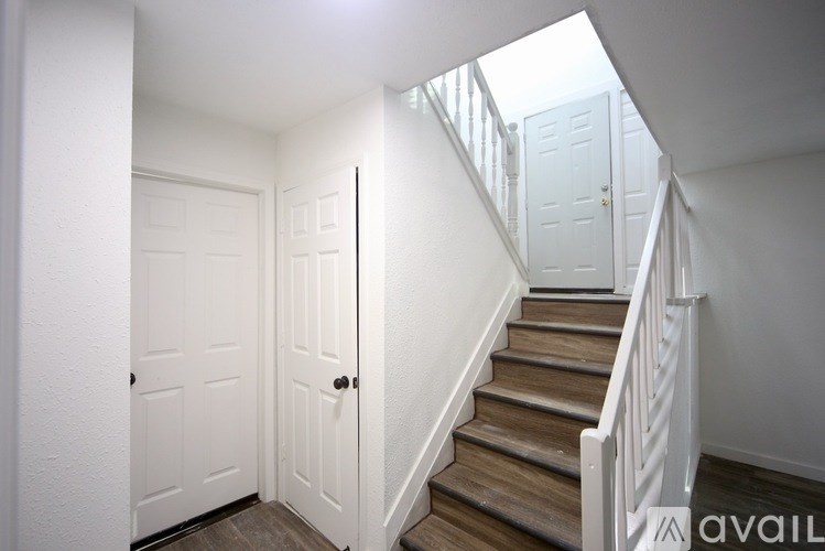 A room with a ceiling fan and two windows.